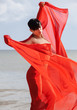 Foto: naked woman on a beach with red fabric naked woman on a beach with red fabric