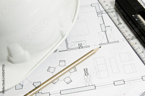 Photo: Blueprint for construction work with helmet and tools Blueprint for construction work with helmet and tools
