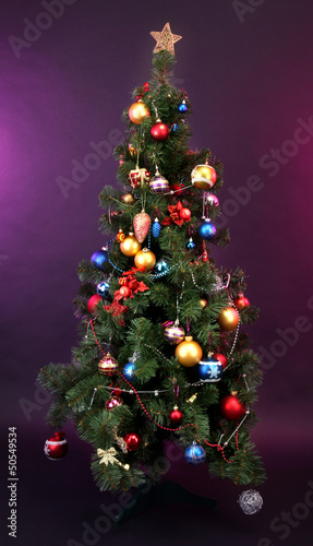 Photo: Decorated Christmas tree on home interior background Decorated Christmas tree on home interior background