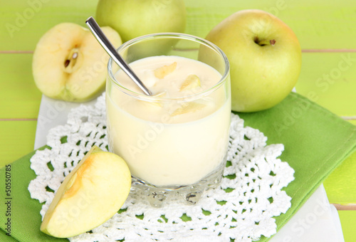 Photo: Delicious yogurt in glass with apple on blue tablecloth Delicious yogurt in glass with apple on blue tablecloth
