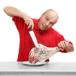 An butcher cutting fresh lamb meat.
