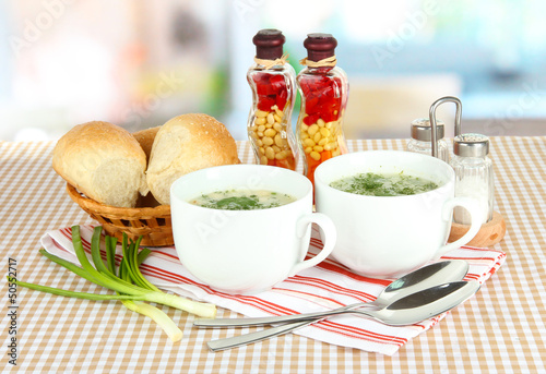Photo: Fragrant soup in cups on table in kitchen Fragrant soup in cups on table in kitchen