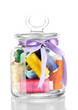 Glass jar containing various colored thread isolated on white