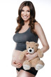 Beautiful smiling pregnant woman with plush toy