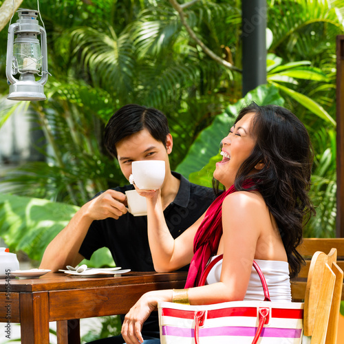 Photo: Asian man and woman in restaurant or cafe Asian man and woman in restaurant or cafe