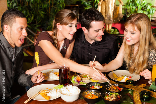 Photo: Young people eating in Thai restaurant Young people eating in Thai restaurant