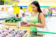 Woman buying apples in a supermarket