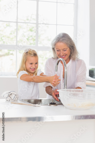Photo: Happy grandmother and granddaughter washing hands Happy grandmother and granddaughter washing hands
