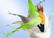 Pretty young woman jumping for joy with artistic paint splashes