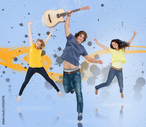 Photo: Young man with guitar and two girls jumping for joy Young man with guitar and two girls jumping for joy