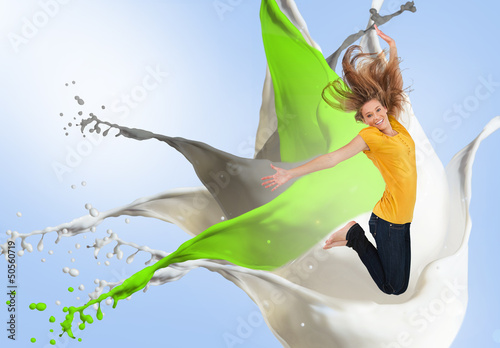 Photo: Pretty young woman jumping for joy with artistic paint splashes Pretty young woman jumping for joy with artistic paint splashes