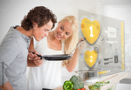 Photo: Couple preparing dinner using futuristic interface Couple preparing dinner using futuristic interface