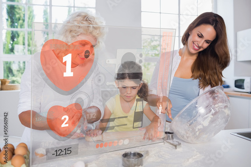 Photo: Granny mother and child making cookies with futuristic interface Granny mother and child making cookies with futuristic interface