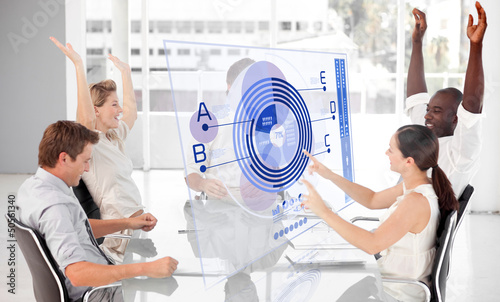 Photo: Cheerful business workers using blue diagram interface Cheerful business workers using blue diagram interface