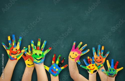 Leinwandbild Motiv bunte Kinderhände vor Schultafel