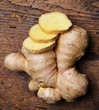 a raw ginger on a wooden background