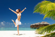 Foto: happy young woman jumping on the tropical beach happy young woman jumping on the tropical beach