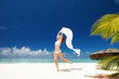 Foto: Happy young woman jumping on the beach Happy young woman jumping on the beach