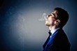 Dark portrait of the young beautiful man. The young man smokes c