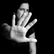 Frightened woman with her hand extended for protection