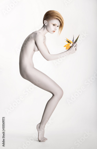 Photo: Imaginary. Expressive Woman in Graceful Pose. Statue with Flower Imaginary. Expressive Woman in Graceful Pose. Statue with Flower