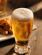 tall glass of beer with foamy head
