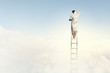 Businesswoman standing on ladder