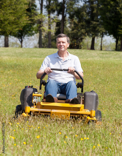 Photo: Senior man on zero turn lawn mower on turf Senior man on zero turn lawn mower on turf