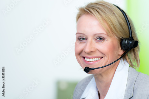 Photo: mitarbeiterin telefoniert mit headset mitarbeiterin telefoniert mit headset