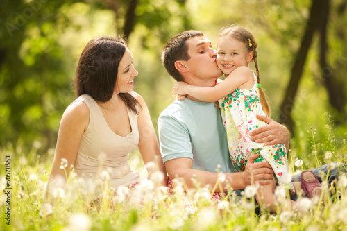 Photo: Happy mother, father and daughter in the park Happy mother, father and daughter in the park