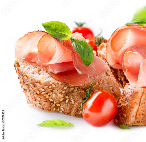 Photo: Jamon. Slices of Bread with Spanish Serrano Ham over White Jamon. Slices of Bread with Spanish Serrano Ham over White