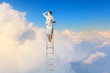 Businesswoman standing on ladder