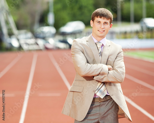 Photo: Businessman at athletic stadium and race track Businessman at athletic stadium and race track
