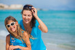 Mother and her daughter in sunglasses on beach