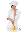 surprised female cook cutting paprika and speaking on the phone