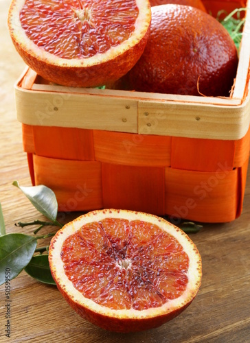 Photo: red (bloody) oranges on a wooden plate red (bloody) oranges on a wooden plate