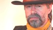 Closeup portrait of very serious cowboy smoking cigar