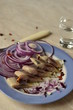 Portion herring fillet with onions and peppers