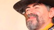 Closeup portrait of cowboy smoking cigar and laughing.
