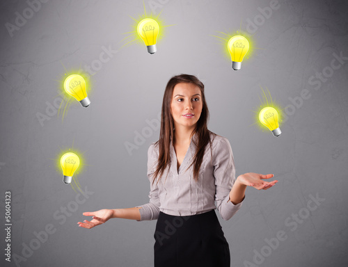 Photo: young lady standing and juggling with light bulbs young lady standing and juggling with light bulbs