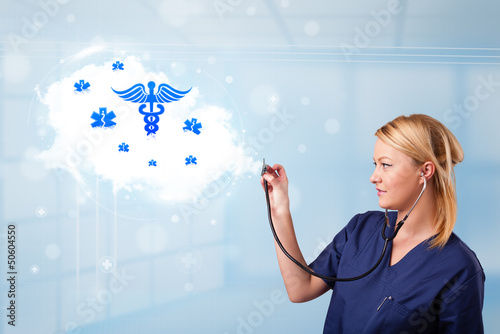 Photo: Young doctor with abstract cloud and medical icons Young doctor with abstract cloud and medical icons