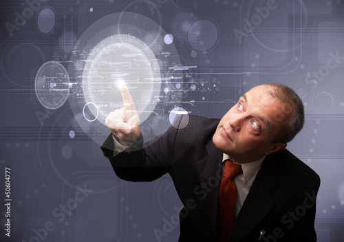 Photo: Businessman touching abstract high technology circular buttons Businessman touching abstract high technology circular buttons