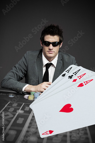 Photo: Gambler in sunglasses with digital cards in foreground Gambler in sunglasses with digital cards in foreground