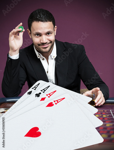 Photo: Handsome gambler betting on four aces Handsome gambler betting on four aces