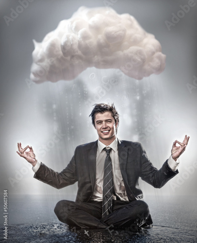 Photo: Businessman meditating under cloud Businessman meditating under cloud