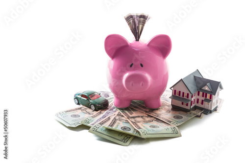 Photo: Piggy bank and toy car resting on pile of dollars Piggy bank and toy car resting on pile of dollars