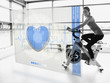 Young attractive girl doing exercise bike with futuristic interf