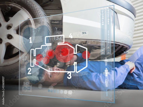 Photo: Laying mechanic consulting interface with an engine Laying mechanic consulting interface with an engine