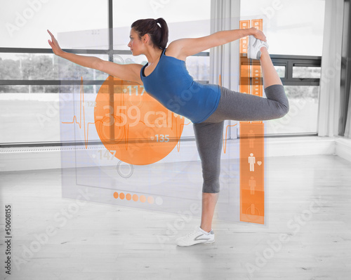Photo: Brunette in yoga pose with futuristic interface next to her Brunette in yoga pose with futuristic interface next to her