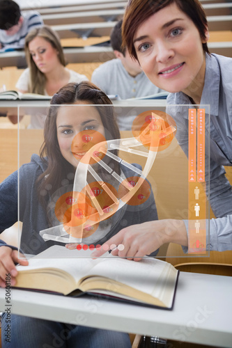 Photo: Teacher and student looking futuristic interface with DNA Teacher and student looking futuristic interface with DNA